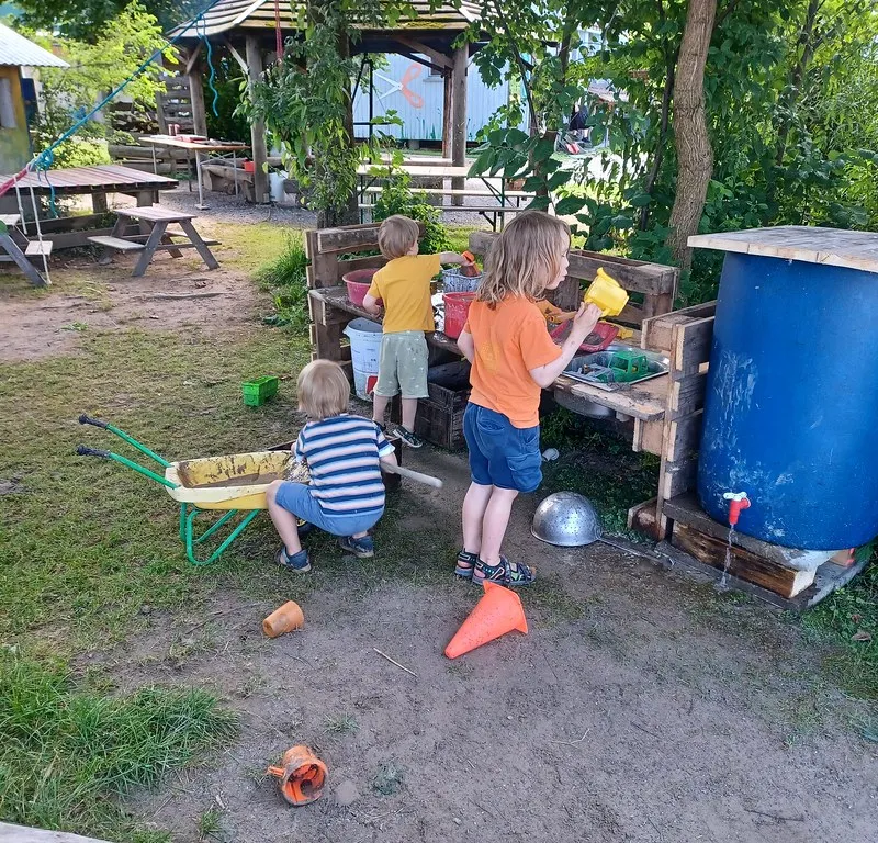 Kinder spielen und werken an einer Wasserstation auf dem Robi.